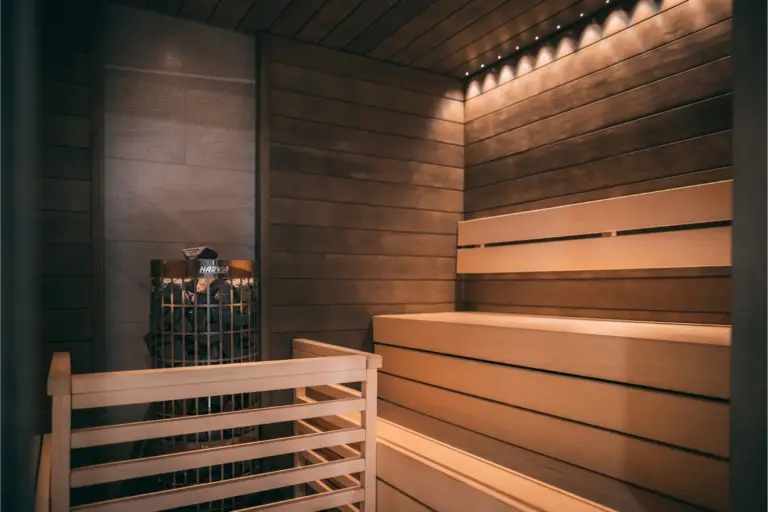 Remontoitu sauna, jossa puiset lauteet ja tunnelmavalaistus